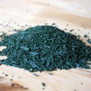 Brindilles de spiruline solidaire Akal saupoudrées sur une salade — texture légèrement croustillante, goût doux, usage quotidien recommandé